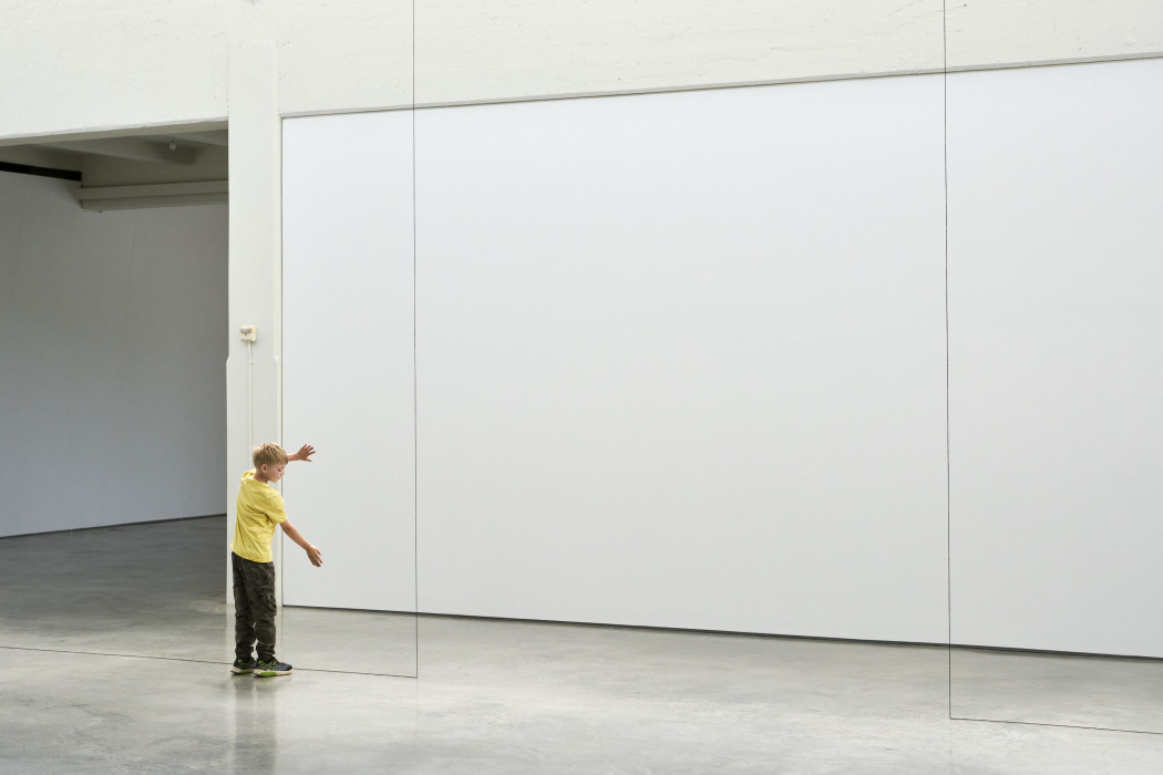 A child stands next to a yearn installation that creates a rectangle in the hallway of Dia Beacon.